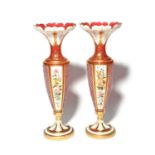 A tall pair of Bohemian glass vases, 19th century, the slender forms overlaid with white over ruby