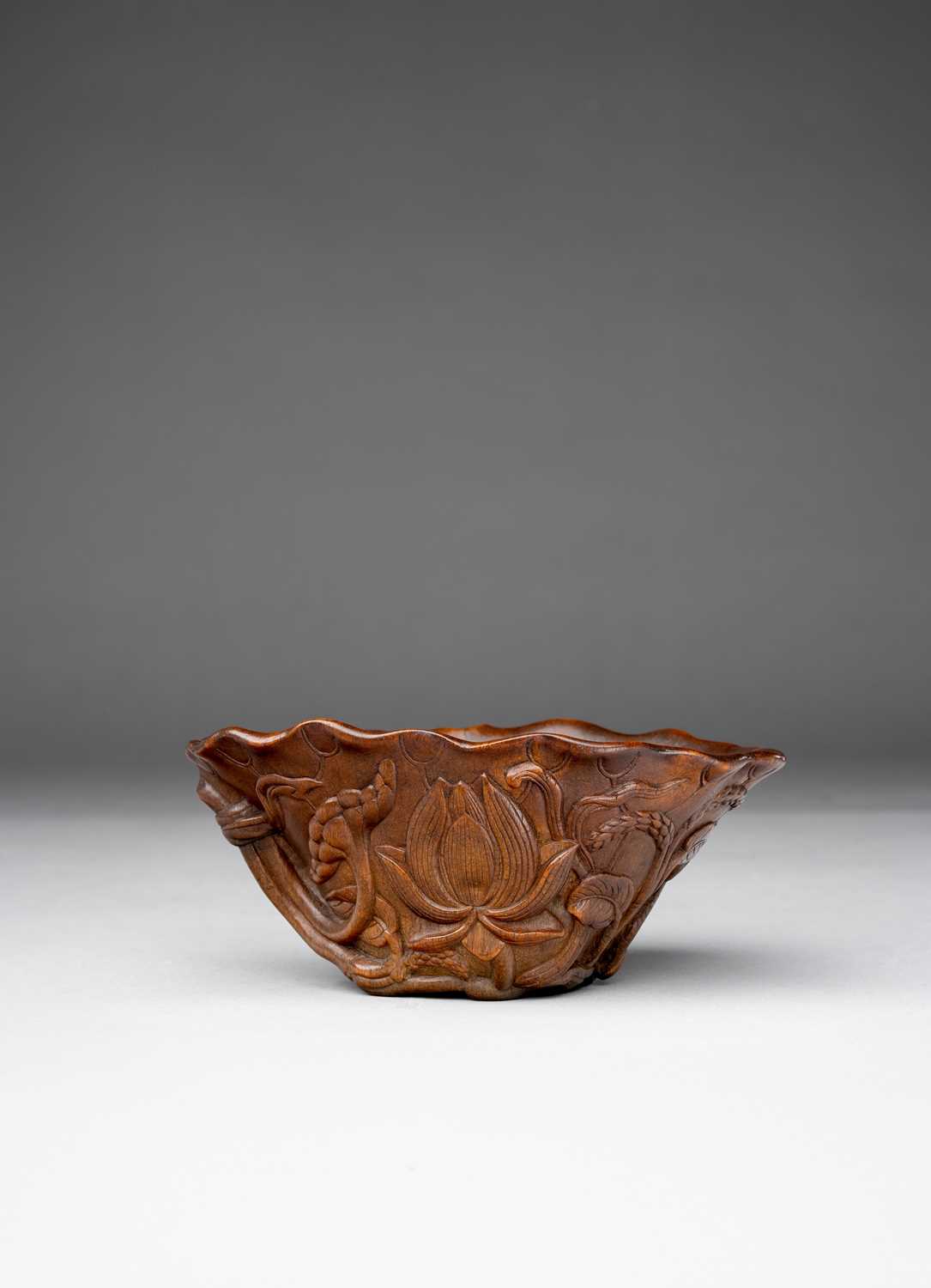 λ A CHINESE RHINOCEROS HORN ‘LOTUS’ LIBATION CUP 17TH/18TH CENTURY The body modelled as a lotus