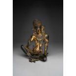 A RARE NEPALESE GILT-COPPER FIGURE OF INDRA 14TH CENTURY Seated in maharajalilasana with his right