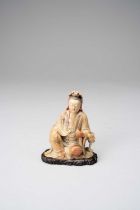 †A RARE CHINESE SOAPSTONE FIGURE OF GUANYIN KANGXI 1662-1722 The Goddess sits in a position of