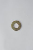 A CHINESE JADE DISC, BI HAN DYNASTY OR EARLIER The celadon-coloured stone with brown streaks and