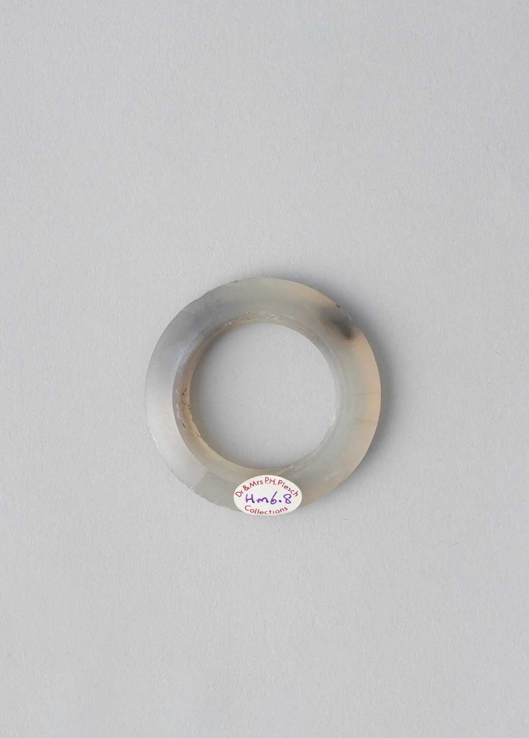 A CHINESE AGATE FACETED RING, HUAN ZHOU DYNASTY Of pale grey colour with darker mottled areas,