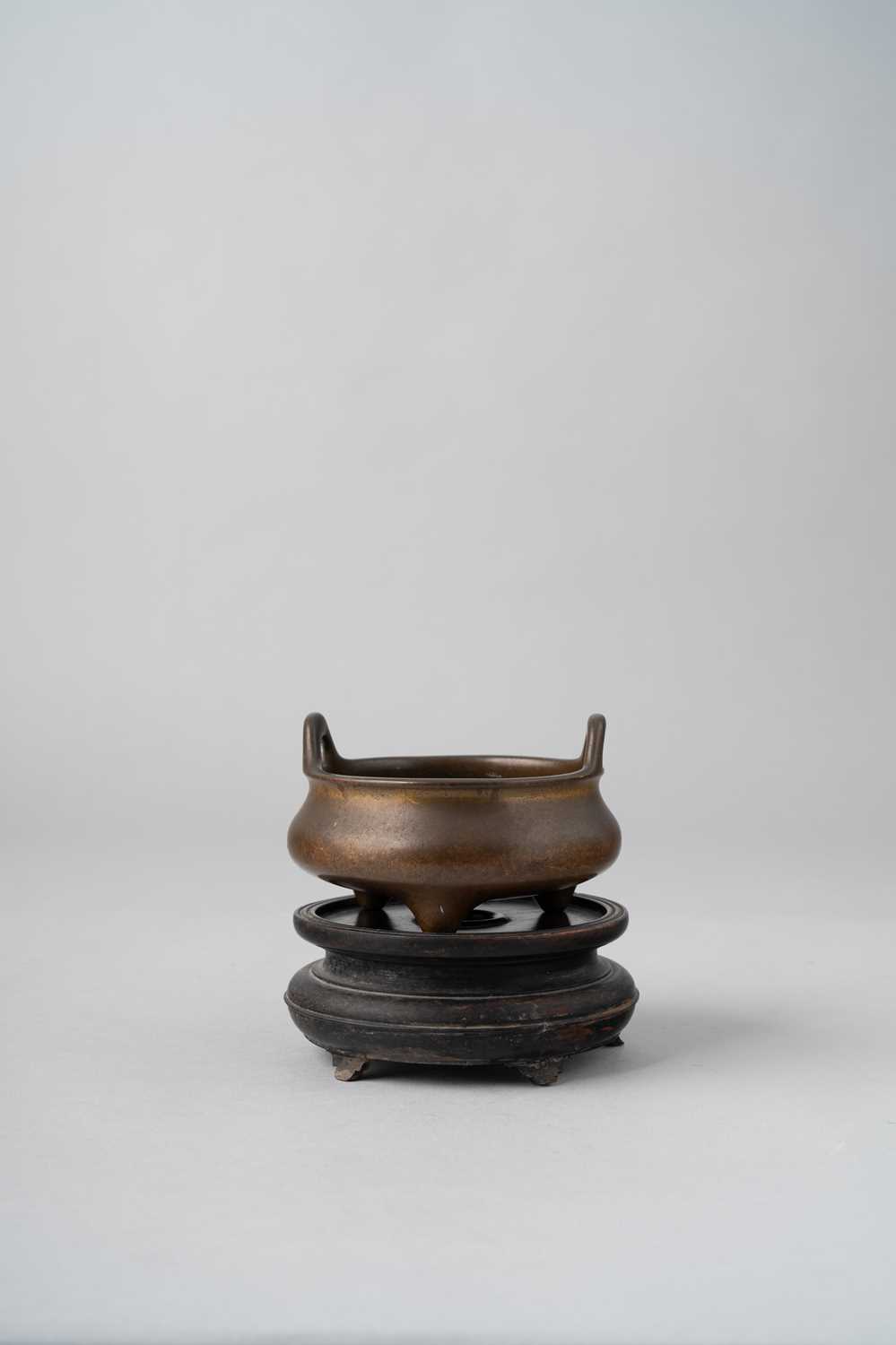 A CHINESE BRONZE TRIPOD INCENSE BURNER QING DYNASTY The compressed circular body with two rounded