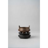 A CHINESE BRONZE TRIPOD INCENSE BURNER QING DYNASTY The compressed circular body with two rounded