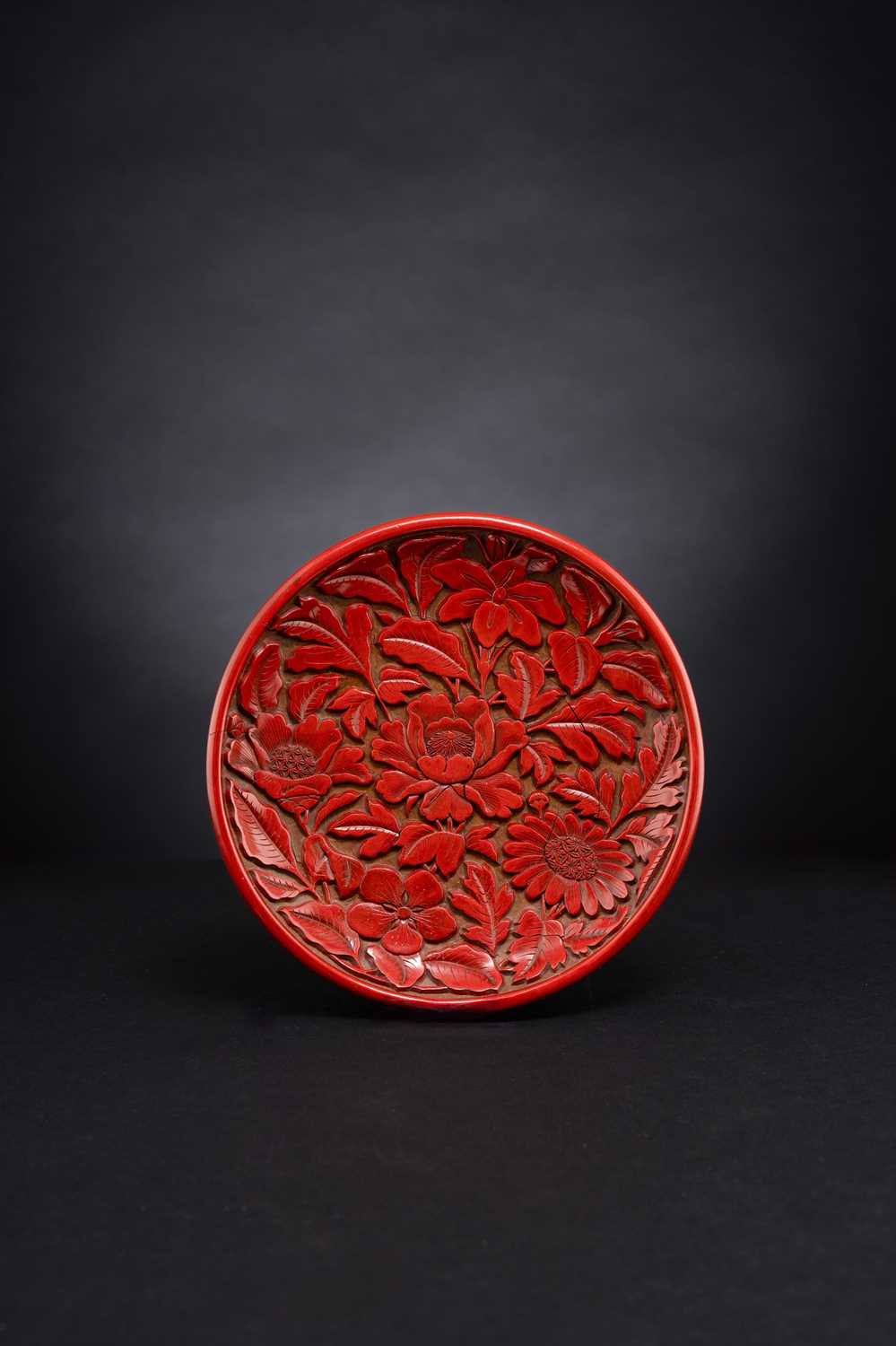 A CHINESE CINNABAR LACQUER 'FLOWERS' DISH YUAN/EARLY MING DYNASTY The interior boldly carved through