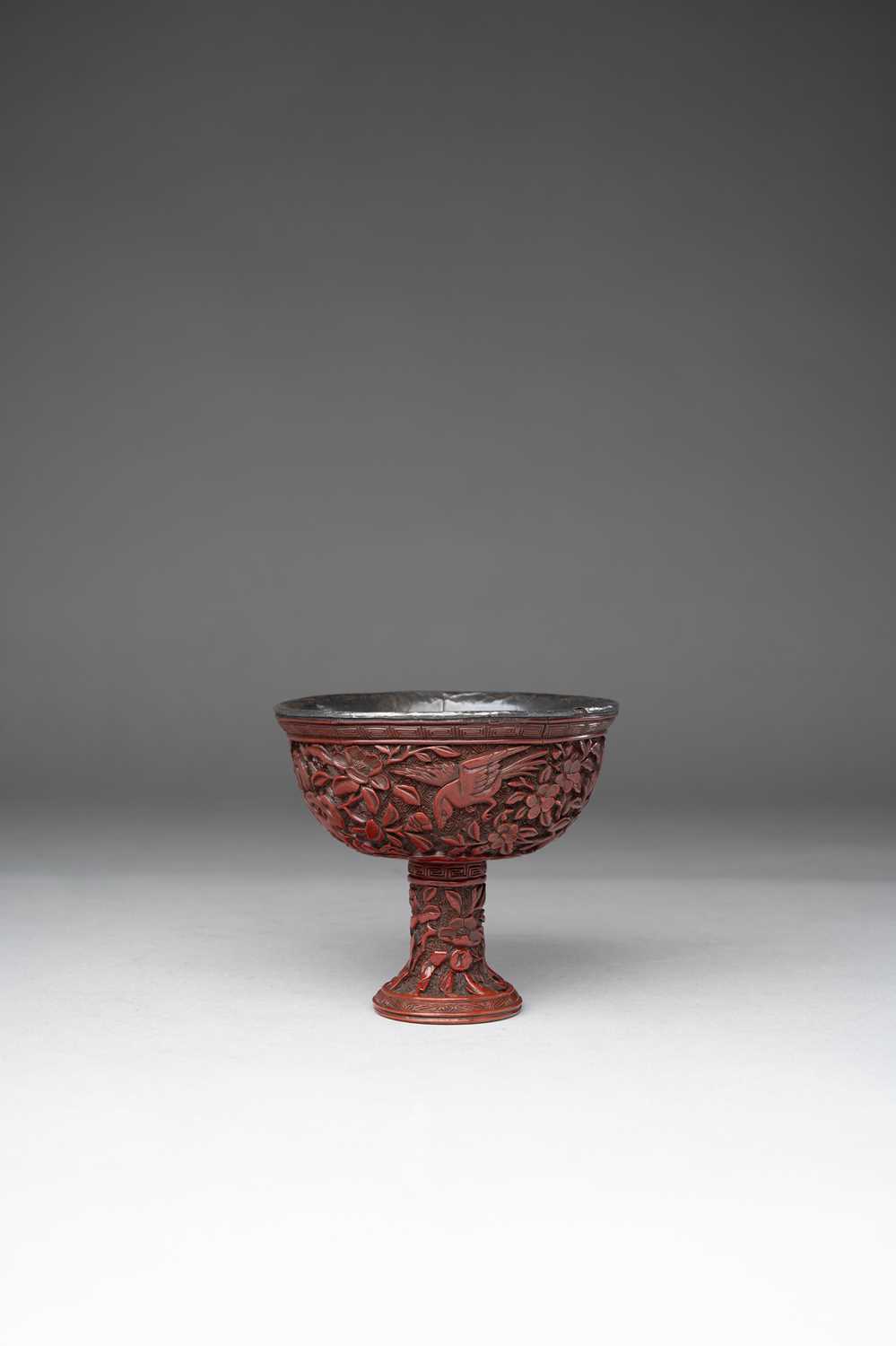 A CHINESE YUNNAN-TYPE CINNABAR LACQUER STEM CUP LATE MING DYNASTY Carved with four magpies among