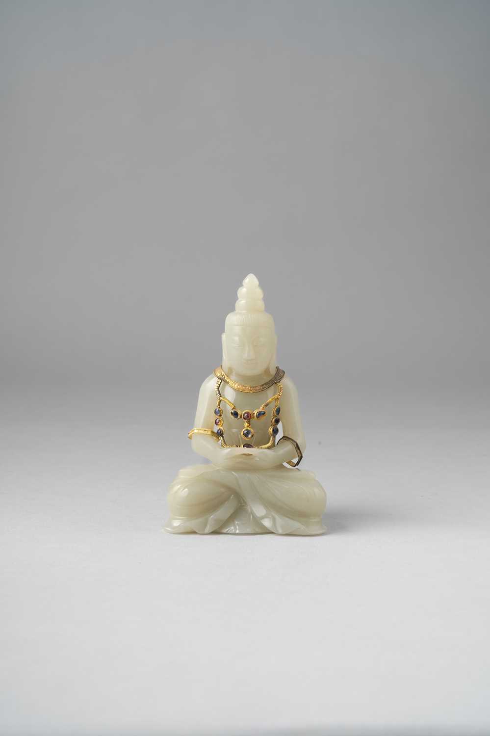 A CHINESE PALE CELADON JADE FIGURE OF BUDDHA 19TH CENTURY Seated in dhyanasana, his hands resting on