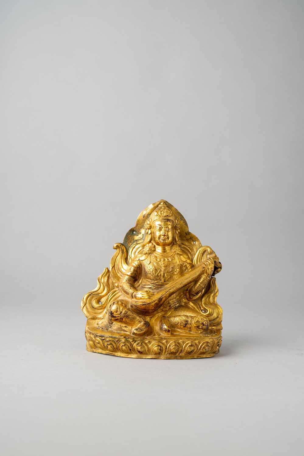 A SINO-TIBETAN GILT-COPPER REPOUSSE FIGURE OF LOKAPALA DHRITARASHTRA 18TH CENTURY Seated on a