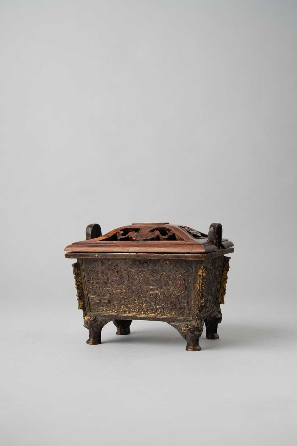 A CHINESE ARCHAISTIC GILT-BRONZE INCENSE BURNER LATE MING DYNASTY The rectangular body with two loop