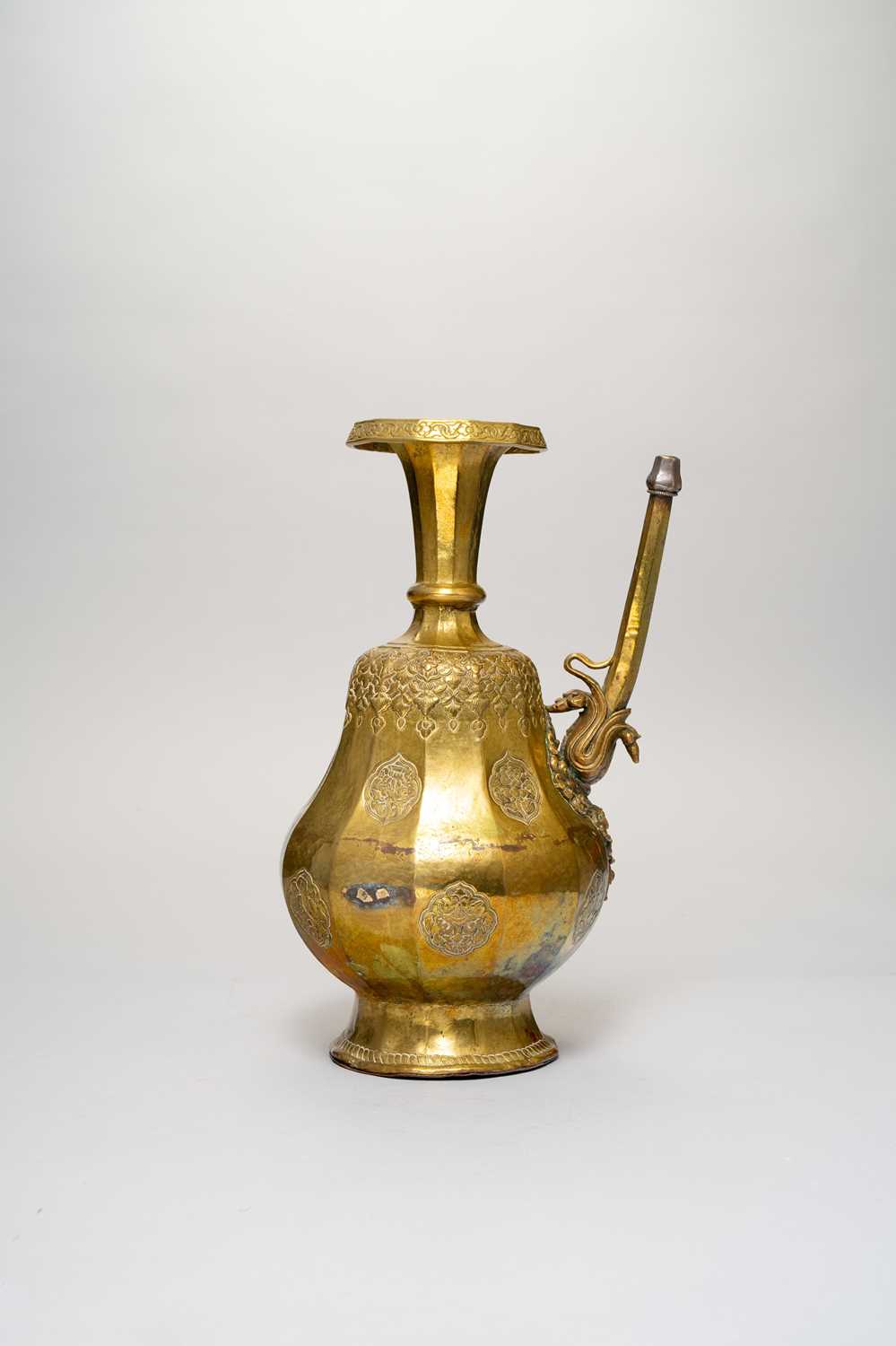 A TIBETAN GILT-COPPER EWER, PENBA HU 18TH/19TH CENTURY The twelve-sided pear-shaped body embossed