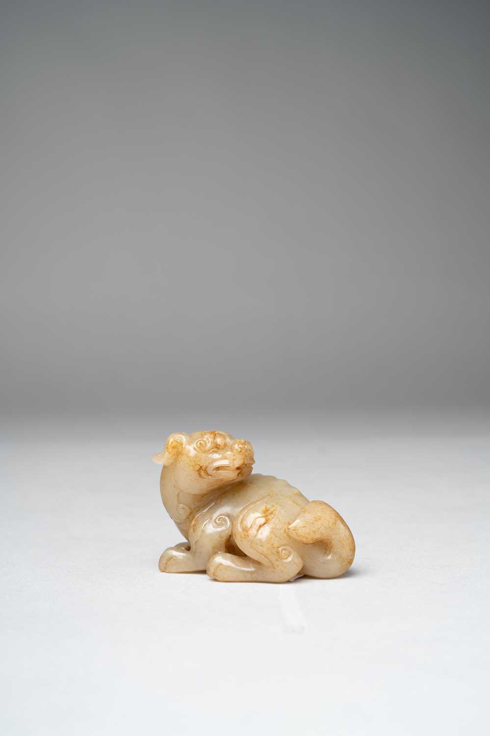 A CHINESE GREY AND RUSSET JADE BUDDHIST LION QING DYNASTY OR LATER The crouching creature carved