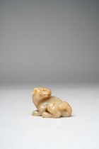 A CHINESE GREY AND RUSSET JADE BUDDHIST LION QING DYNASTY OR LATER The crouching creature carved