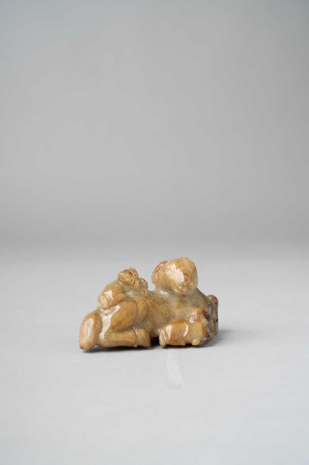 A CHINESE CELADON AND RUSSET JADE 'THREE RAMS' GROUP SONG-MING DYNASTY Depicting a large,