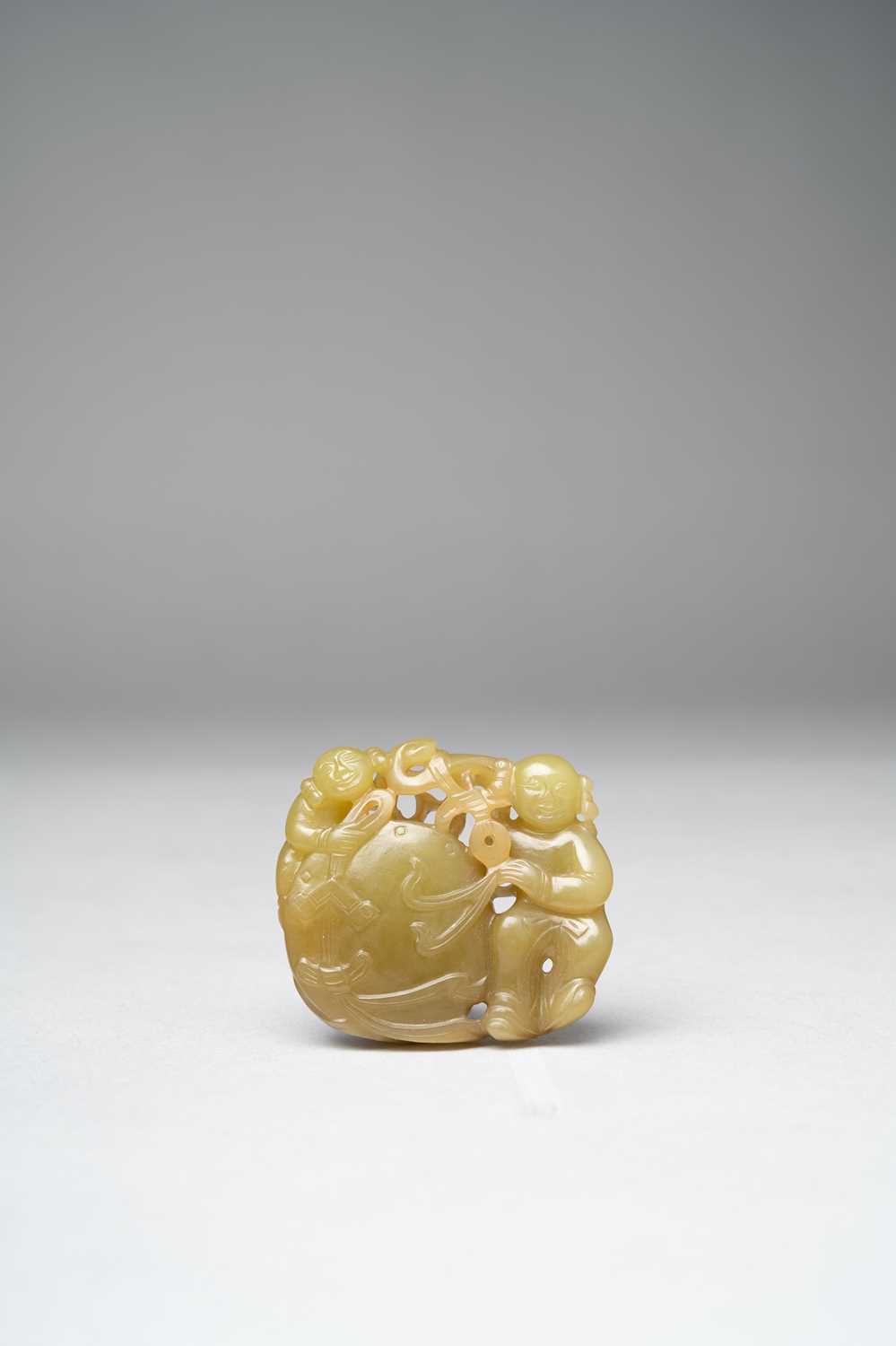 A CHINESE YELLOW JADE 'BOYS AND DRUM' GROUP QING DYNASTY OR LATER Carved in openwork with two boys