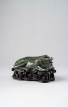 A CHINESE SPINACH-GREEN JADE CARVING OF A WATER BUFFALO 20TH CENTURY The recumbent beast with its