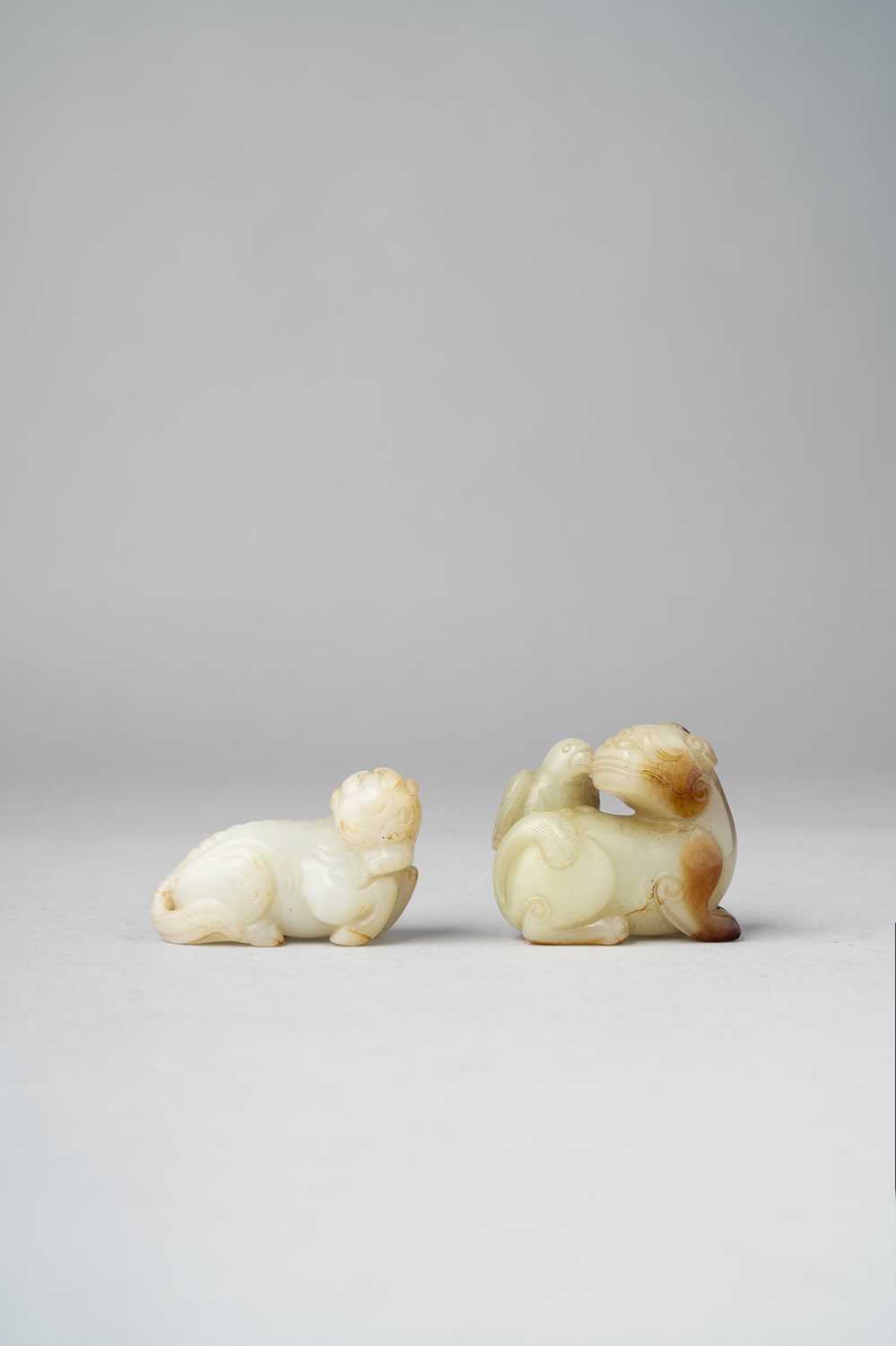 TWO CHINESE JADE CARVINGS OF MYTHICAL BEASTS QING DYNASTY One a pale celadon carving of a