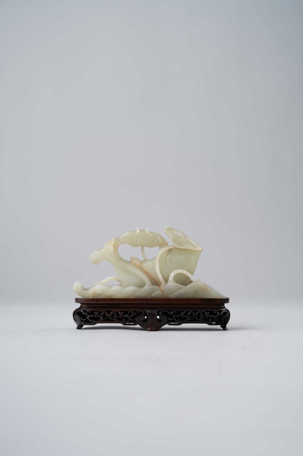 A CHINESE CELADON JADE CARVING OF A CARP QING DYNASTY Emerging from rolling waves, its upturned body - Image 2 of 2