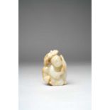 A CHINESE PALE CELADON CARVING OF A BOY AND A BADGER QING DYNASTY Depicting a kneeling boy holding a