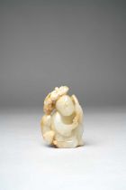 A CHINESE PALE CELADON CARVING OF A BOY AND A BADGER QING DYNASTY Depicting a kneeling boy holding a