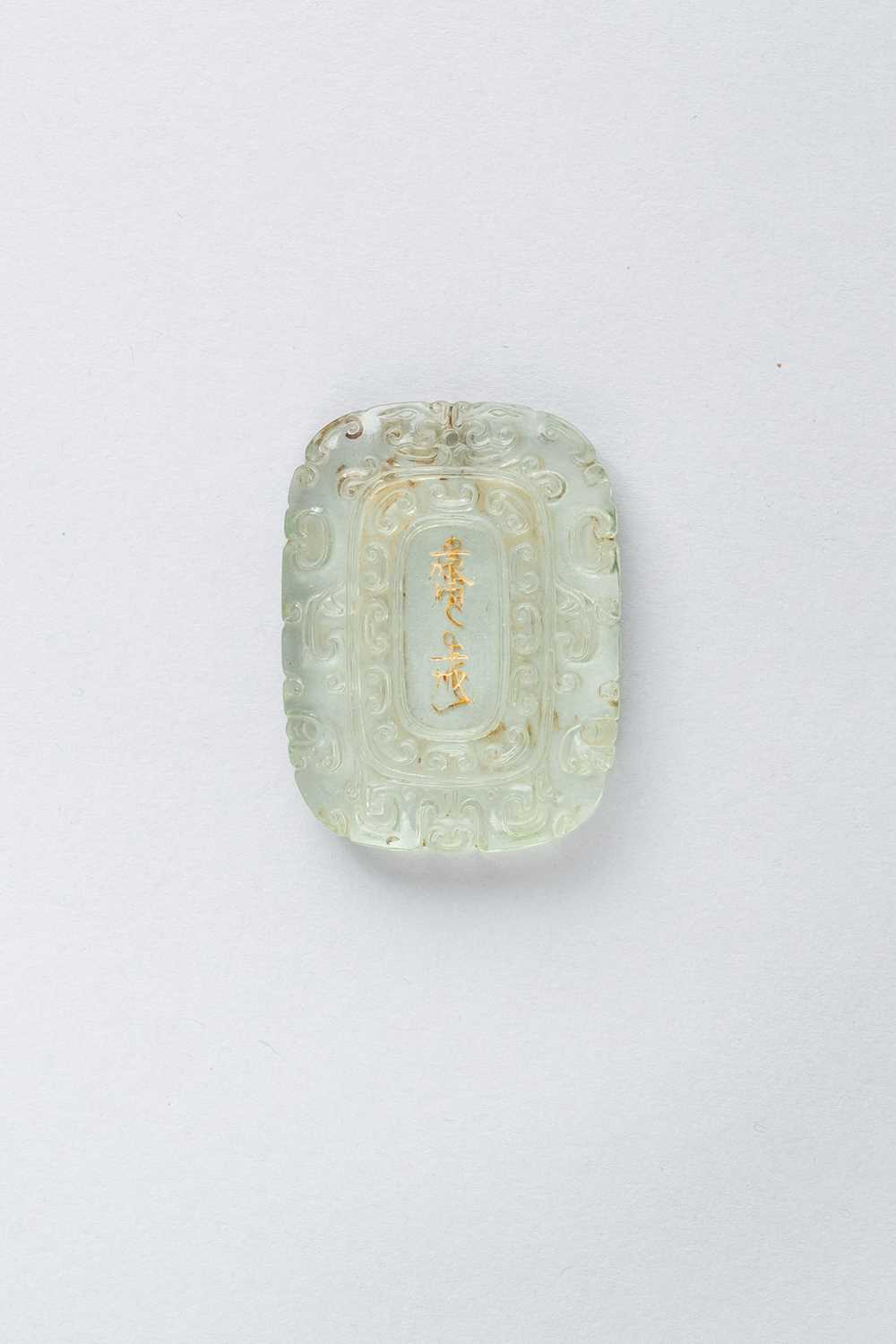 A CHINESE GLASS ABSTINENCE PLAQUE QING DYNASTY OR LATER The pale lime green pendant decorated with