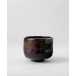 A JAPANESE BLACK RAKU CHAWAN (TEA BOWL) EDO PERIOD, 18TH-19TH CENTURY The U-shaped bowl raised on