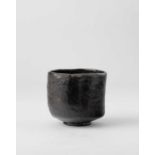 A JAPANESE BLACK RAKU CHAWAN (TEA BOWL) EDO PERIOD, 18TH-19TH CENTURY The tall cylindrical body