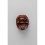 NO RESERVE A JAPANESE WOOD MASK NETSUKE EDO/MEIJI, 19TH CENTURY Depicting a grimacing face below a