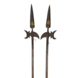 A pair of ornamental halberds, heads with crescent-shaped axe blades and curved rear spikes and