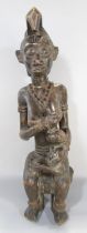 An African carving in the Congolese style of a woman breast feeding a baby, 66cm high.