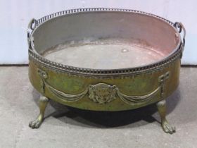 An oval brass planter with classical tied ribbon, swag and mask detail, removable liner and swept
