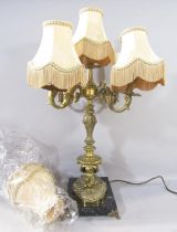 A five branch candelabra table lamp in the Georgian style with elaborate gold arms supported by