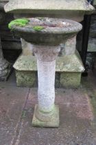 Weathered cast composition stone two section bird bath with circular top, raised on a classical