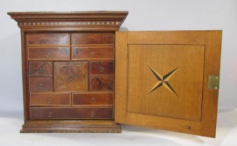 A 19th century collectors cabinet in oak with mahogany banding, the door opening to reveal a
