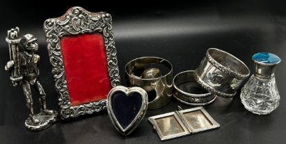 A mixed selection of silver including a photo frame 9 x 6 cm, a silver locket, two napkin rings, a