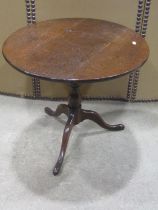 Two low oak occasional tables of circular form with turned pillars and swept tripods, 58 cm diameter