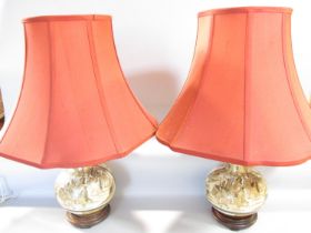 A pair of Japanese Satsuma vases converted to electric lamps, both with red silk pagoda lamp shades.