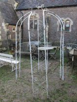 A painted light steel tubular framed sectional gazebo or arbour with simple repeating open