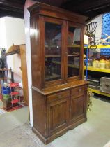A late 19th century ashwood library bookcase, the lower section enclosed by two panelled doors and