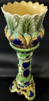 A late 19th century majolica jardiniere and stand with scrolling acanthus and other detail