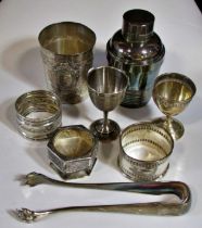 A silver French beaker, bearing the head of Minerva, two napkin rings, a clawed sugar tong, three