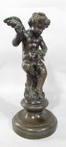 A 19th century bronze of Cupid preparing an arrow whilst sat on a tree stump, raised on a socle