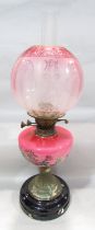 A Victorian oil lamp with a rose pink floral font and etched glass shade, 57cm