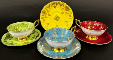 Three Coalport tea cups and four matching saucers in a turquoise, lime green and maroon colourway