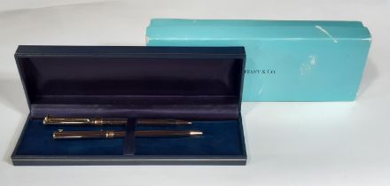 Tiffany & Co ballpoint pen and matching propelling pencil set in silver and gold plated finish, with