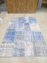 A Turkish patchwork patchwork carpet in patches of blues and turquoise, on a backing 239cm 170cm.