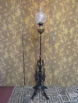 A late Victorian telescopic oil lamp standard with good quality scrolled wrought iron base beneath a