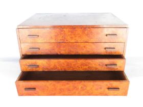 A burr walnut four drawer collectors chest on a plinth base, 50cm wide x 31.5 cm high x 33cm deep.