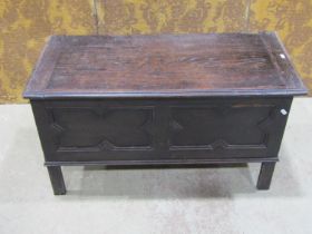 A dark stained oak blanket box in the Jacobean style with hinged lid over a geometric moulded