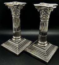 A pair of silver Corinthian column candlesticks with removal sconces on square stepped bases, London