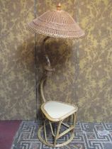 A vintage bound cane work low table and combined lamp with raised shaped neck supporting a tilted